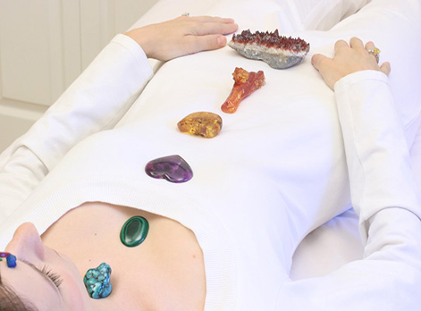 Woman laying down having Crystal Healing on her seven chakras